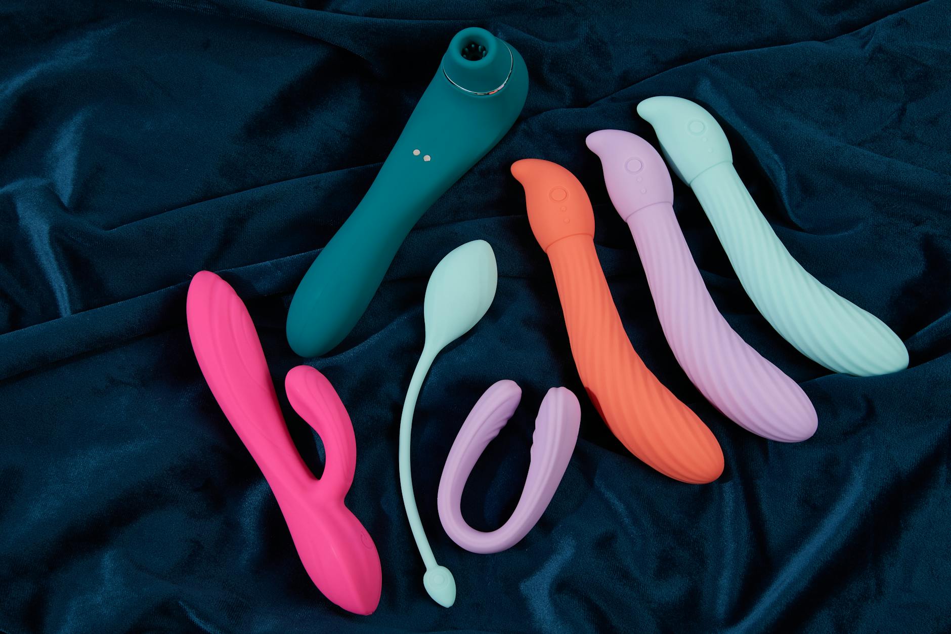 Vibrant arrangement of colorful sex toys on a bright yellow surface