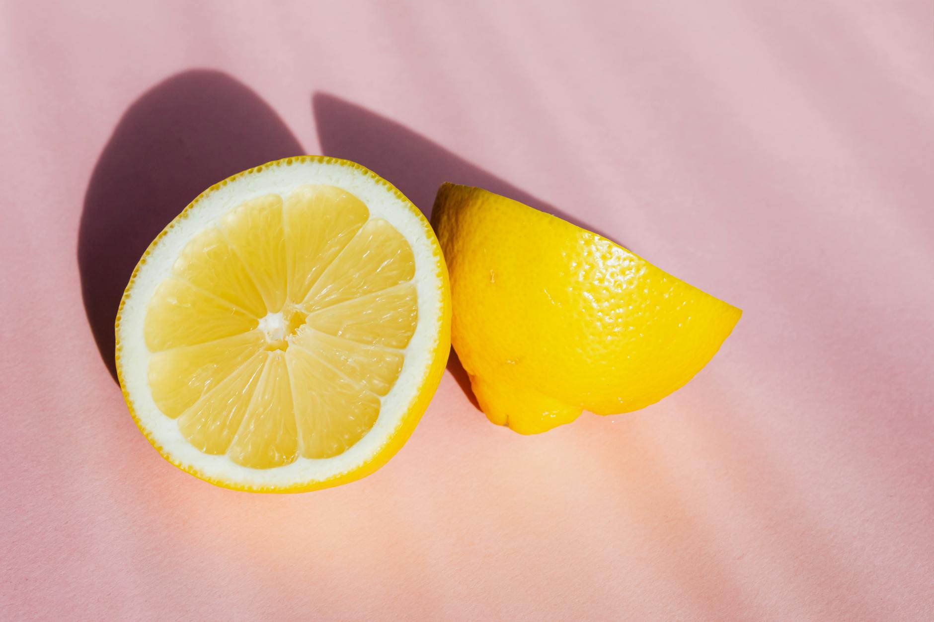 Fresh yellow lemons on a pink background, symbolizing renewal and vitality