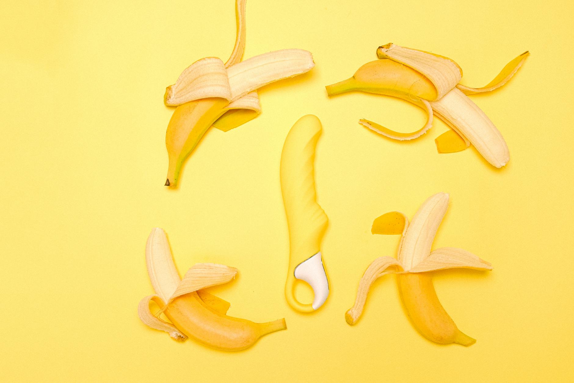 A yellow lemon-shaped vibrator surrounded by fresh lemons on a bright yellow background, symbolizing reclaiming sensual pleasure.