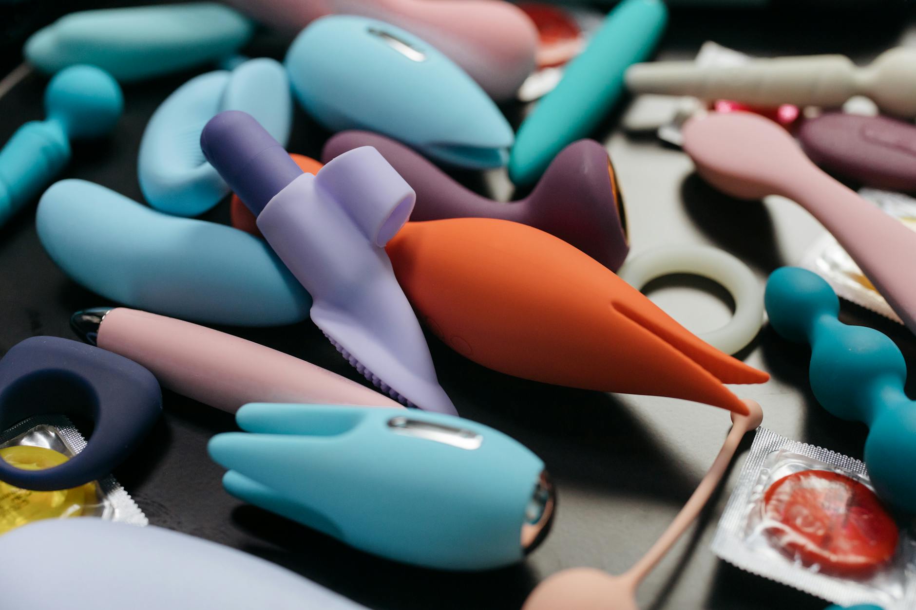 Hand holding a lemon-colored vibrator against a purple backdrop, representing intimate exploration