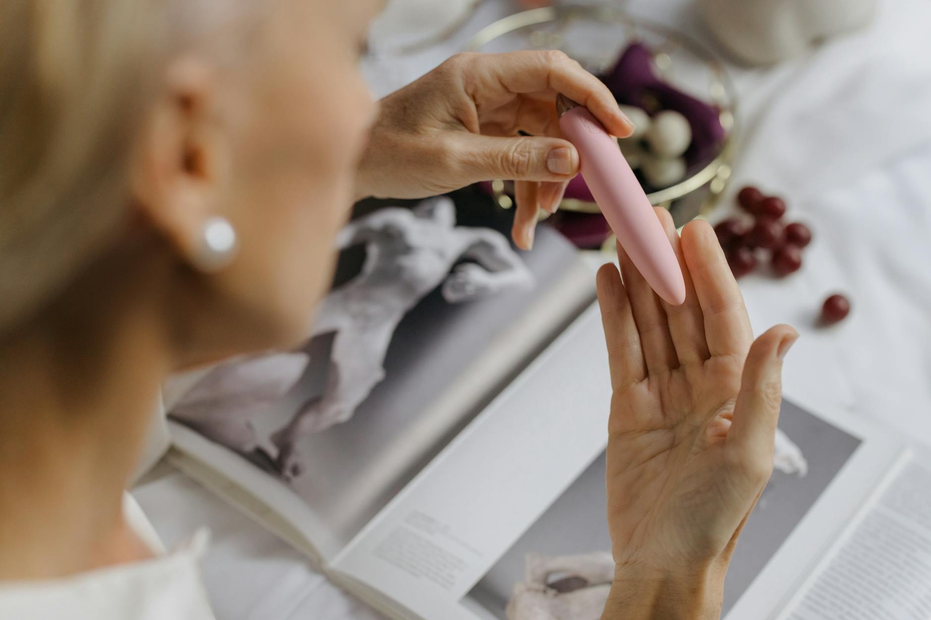 A close-up of hands holding a vibrator in soft lighting, emphasizing the intimacy and personal wellness aspect of rebuilding desire.