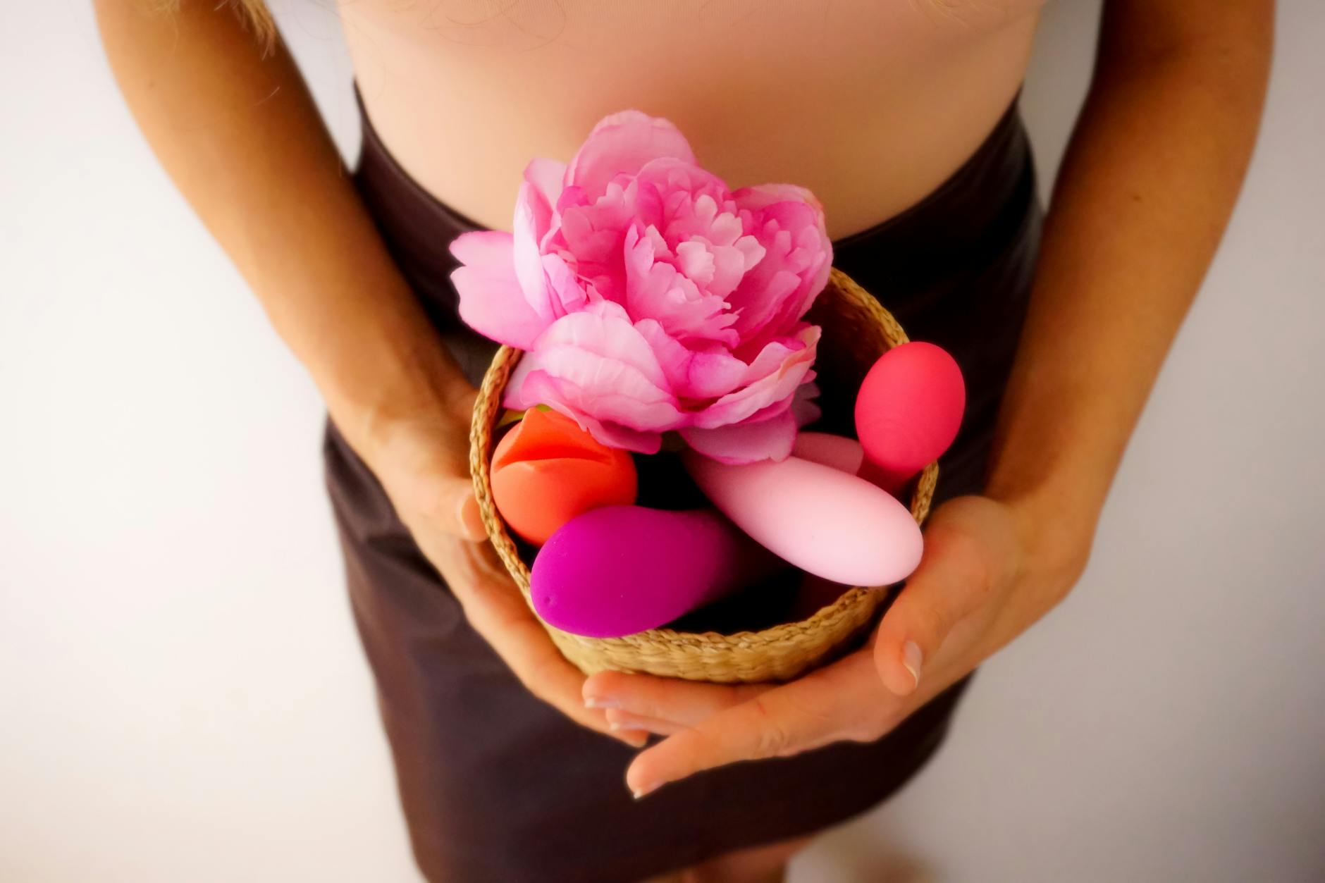 Vibrant arrangement of various colorful sex toys on a bright yellow surface